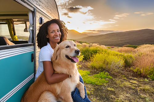 Lady siting next to her truck with her golden retriever